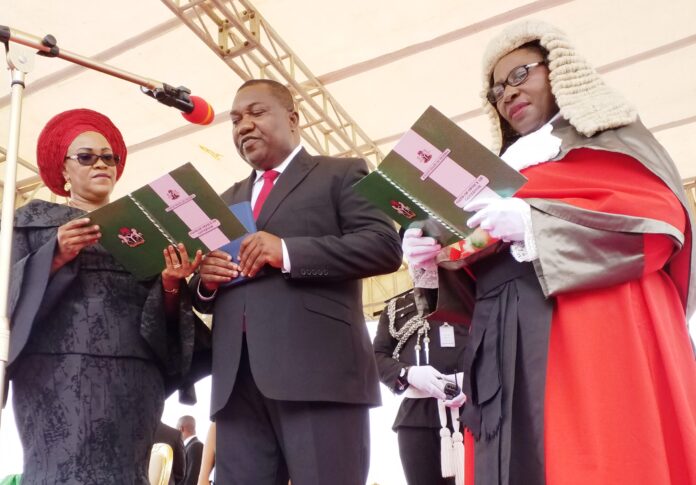 Enugu State Governor, Rt. Hon. Ifeanyi Ugwuanyi (middle) being sworn in for a second term by the Chief Judge of the State, Hon. Justice Priscilla Ngozi Emehelu (right), at Michael Okpara Square, Enugu, yesterday. With him on the left is his wife, Monica Enugu State Governor, Rt. Hon. Ifeanyi Ugwuanyi (middle) being sworn in for a second term by the Chief Judge of the State, Hon. Justice Priscilla Ngozi Emehelu (right), at Michael Okpara Square, Enugu, yesterday. With him on the left is his wife, Monica