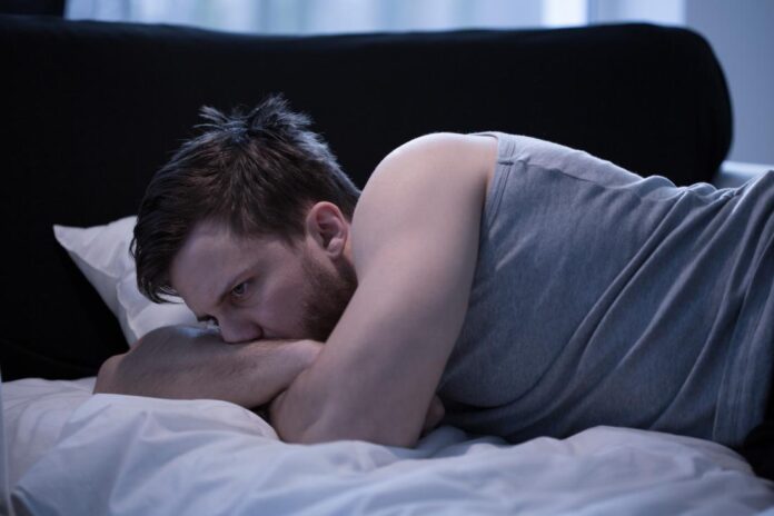 man-awake-in-bed-with-possible-wet-dream