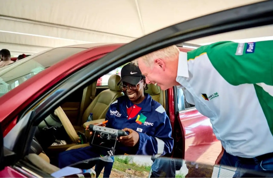 A female mechanic diagnosing a car while the Managing Director, NNPC Retail Ltd, Mr. Huub Stokman watches keenly during the NNPC Retail She-Fix 2025 event, held in Lagos